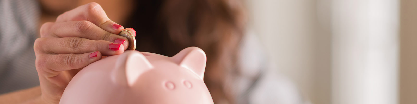 a person placing money in a piggy bank