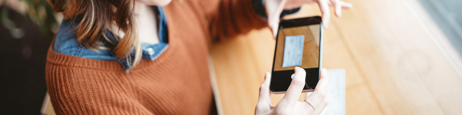 a lady taking a mobile picture of her check