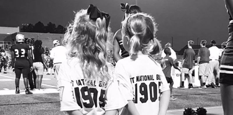 Cheerleader girls at the sideline of football game.