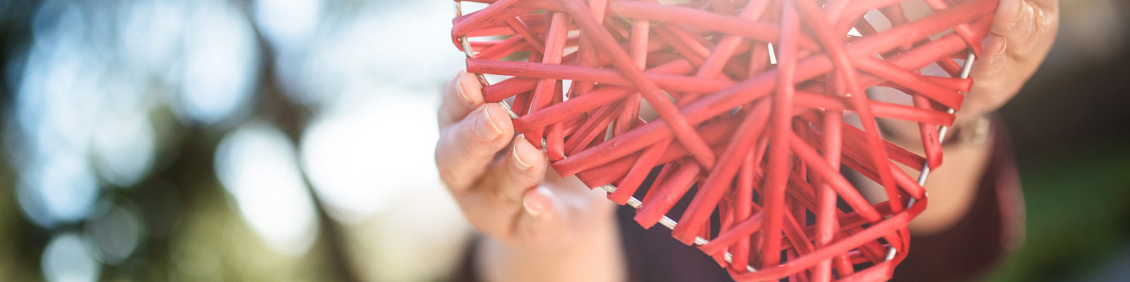 a person holding a craft heart